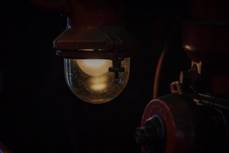 An atmospheric light from an antique lamp in a dark part of a locomotive, Dahlhausen railway depot,
