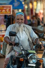 Muslim man on motorbike, bazaar, at Charminar, Hyderabad, Andhra Pradesh, India, Asia