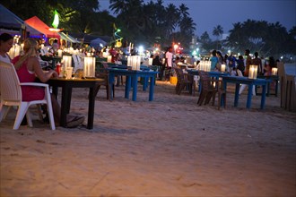 People sitting at tables of beach bar, Mirissa, Sri Lanka, Asia