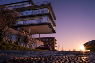 Modern residential building in the light of the sunset with parked cars, University, Pforzheim,