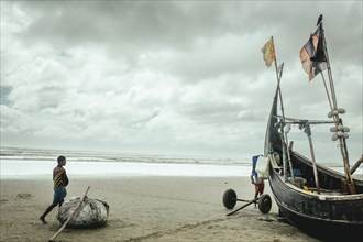 Fishing boat on the beach during a monsoon shower, Cox's Bazar, Bangladesh, Asia
