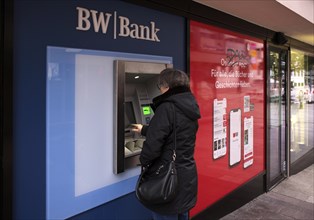 Elderly woman, best ager, types in PIN, ATM of BW-Bank Baden-Wuerttembergische Bank, logo,
