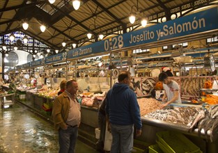 People shopping at fishmonger stalls inside historic covered market building, Jerez de la Frontera,