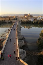 Roman bridge spanning river Rio Guadalquivir with Mezquita cathedral buildings, Cordoba, Spain,