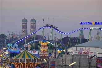 View over the Oktoberfest, in the evening with alpine railway in front of the Church of Our Lady,