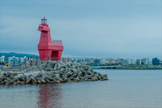 Red lighthouse built to look like horse on concrete prier in Jeju, South Korea, Asia