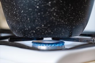 Closeup view of a pan on a gas hob, cooking on a gas stove