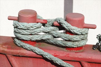 Red ship's bollard wrapped with ship's rope, mooring line, Germany, Europe