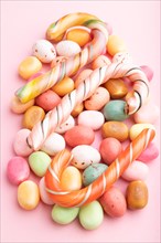 Various caramel candies on pink pastel background. close up, side view