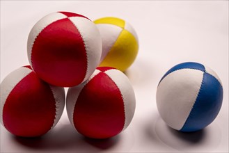 Several juggling balls in front of a white background, partially stacked, studio shot, Germany,