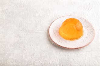 Papaya and orange jelly on gray concrete background. side view, copy space