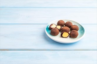 Japanese rice sweet buns chocolate mochi filled with cream on blue wooden background. side view,