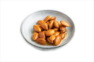 Almonds with honey isolated on white background. side view, close up