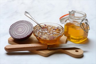 Honey in a jar and chopped onion as ingredients for cough syrup