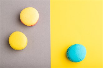 Yellow and blue macaroons on trendy gray and yellow background. top view, copy space, flat lay,