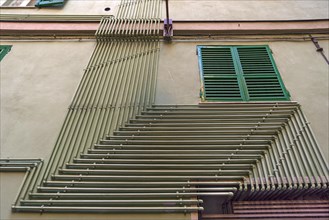 Water pipes on an exterior wall of a residential building in the historic centre, Genoa, Italy,