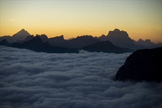 Sunrise over a sea of fog with the peaks of the Sella massif in the background, Corvara, Dolomites,