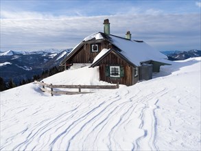 Winter atmosphere, snow-covered landscape, snow-covered alpine peaks, alpine hut on the