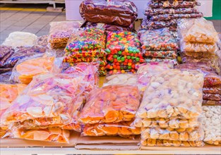 Clear bags of candy and dried fruit on display for sale at flea market in Sintanjin, South Korea,