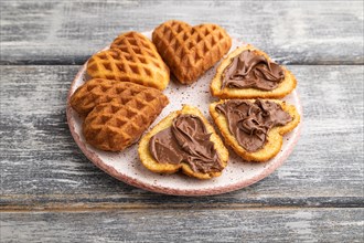Homemade waffle with chocolate butter on a gray wooden background. side view, close up