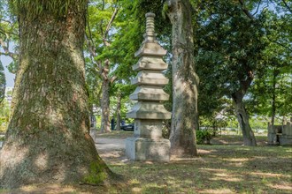 Stone carved pagoda in shady area of Peace Memorial Park in Hiroshima, Japan, Asia