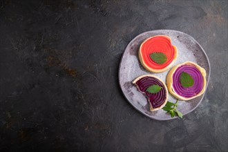 Sweet tartlets with jelly and milk cream on a black concrete background. top view, flat lay, copy