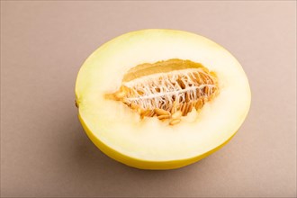 Sliced ripe yellow melon on brown pastel background. Side view, close up. harvest, women health,