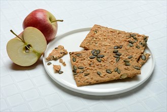 Crispbread with seeds on a plate and apple