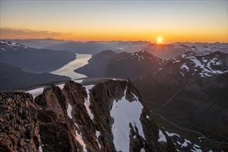 View of mountains and fjord Faleidfjorden, sun star at sunset, summit of Skala, Loen, Norway,