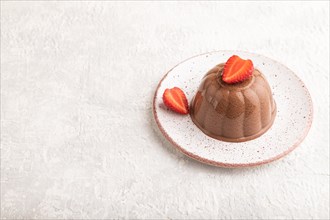 Chocolate jelly with strawberry on gray concrete background. side view, copy space