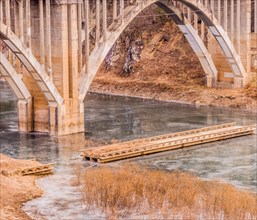 Arch bridge with columns spanning a river with a smaller bridge with pieces missing in South Korea