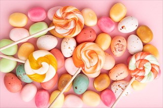 Various caramel candies on pink pastel background. close up, top view, flat lay