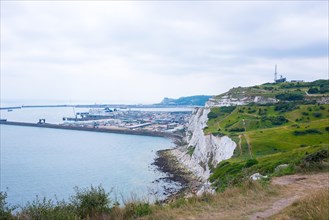 View of the harbour and town of Dover, ship in the bay, next to impressive chalk cliffs under a