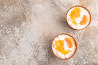 Grained cottage cheese with tangerine jam on brown concrete background. top view, flat lay, copy