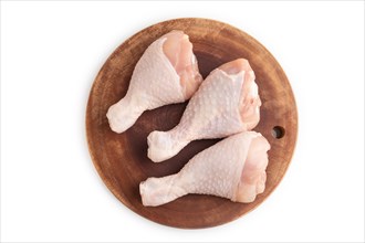 Raw chicken legs on a wooden cutting board isolated on white background. Top view, flat lay, close