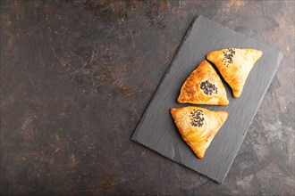 Homemade asian pastry samosa on black concrete background. top view, flat lay, copy space