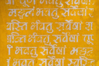 Sanskrit mantra, white writing on yellow background, Tamil Nadu, India, Asia