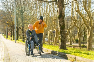Caregiver pointing ahead talking to a disabled man in an urban park