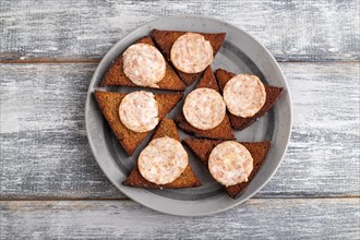 Sausage and toast on a gray plate on a gray wooden background. Top view, flat lay, close up