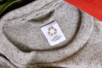 Gray pullover with with label saying '100% recycled fabric'