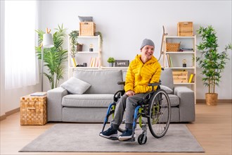 Portrait with copy space of a happy disabled man in warm clothes using wheelchair in the living