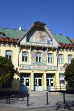 Art Nouveau building on a sunny day with blue sky and green roof, artistic facade, House of