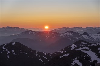 Sunset behind the mountains, mountain panorama with remnants of snow from the summit of Skala,