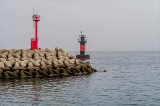 Two lighthouses at entrance to small island harbor on overcast morning in Jeju, South Korea, Asia