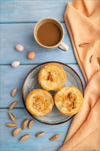 Traditional portuguese cakes pasteis de nata, custard small pies with almonds with cup of coffee on