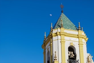 01, 22, 2024 ronda, malaga, spain Close-up of a church steeple with a blue sky and the moon in the