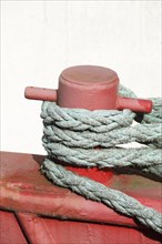 Red ship's bollard wrapped with ship's rope, mooring line, Germany, Europe