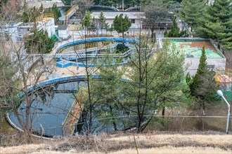 Water treatment plant with pools of water nestled among trees in rural setting. Shot from hill