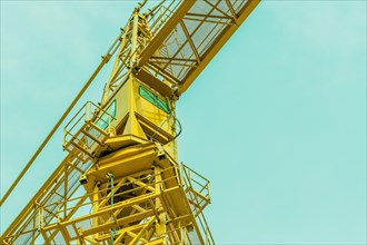 Large yellow construction crane with a background of a clear blue sky