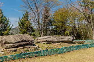 Ancient boulders in fenced rock garden in wilderness mountain park in South Korea